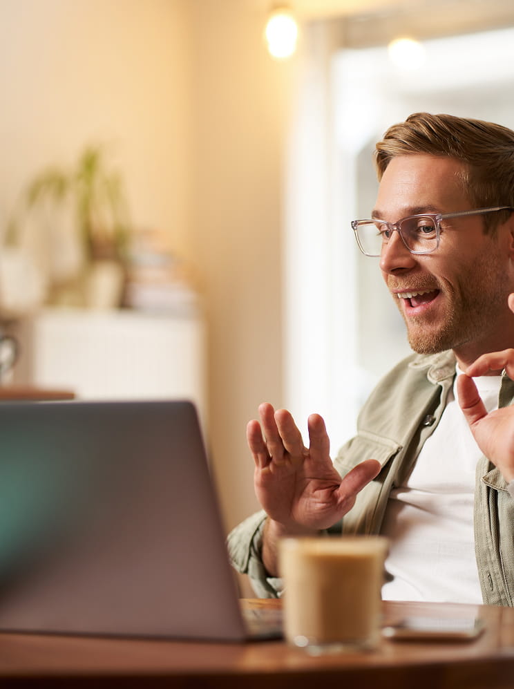 Un uomo con occhiali parla davanti a un laptop