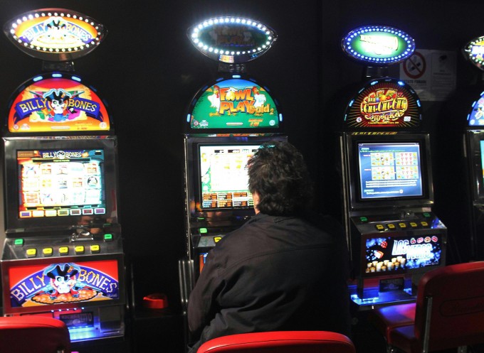 uomo di spalle che gioca alla slot machine