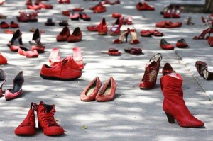 una moltitudine di scarpe femminili rosse simbolo di protesta della violenza contro le donne