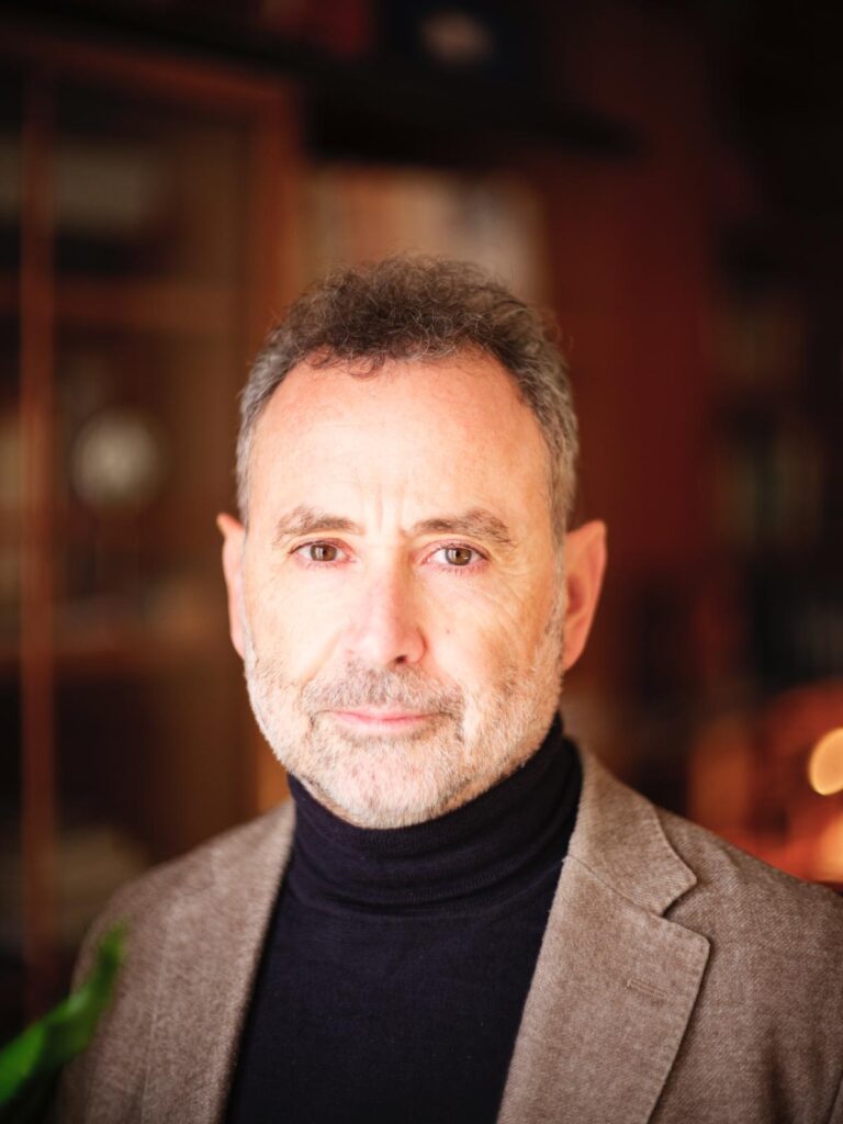 Uomo con barba e maglione a collo alto, sorridente